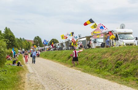 Quievy,France - July 07, 2015:Spectators and caravans are on the cobblestone road during the stage 4 of Le Tour de France 2015 in Quievy, France, on 07 July,2015.のeditorial素材