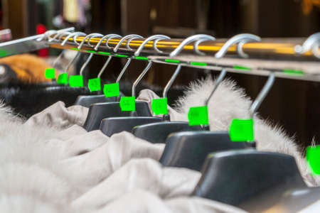 Image of a row of hangers in a clothes boutique. Shallow depth of field.