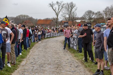 Templeuve, France - April 08, 2018: The spectators are waiting for the peloton on the cobblestone road in Templeuve during Paris-Roubaix 2018.のeditorial素材