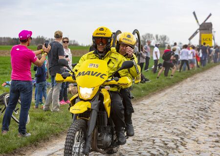 Templeuve, France - April 08, 2018: The yellow bike of Mavic driving on the cobblestone road in Templeuve during Paris-Roubaix 2018.のeditorial素材