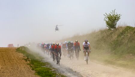 Viesly, France - April 14, 2019: The peloton riding on the dusty cobblestone road from Briastre to Viesly during Paris Roubaix 2019.のeditorial素材