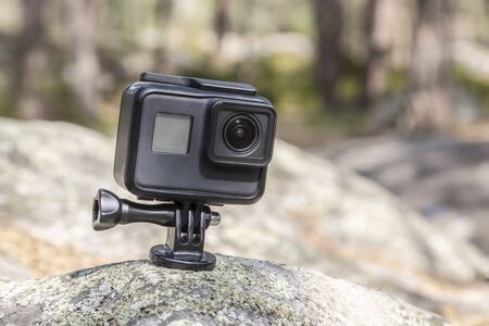 Image of an action camera outdoors on a rock in a forest.の写真素材