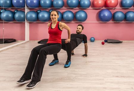 Young couple doing exercises in a gym