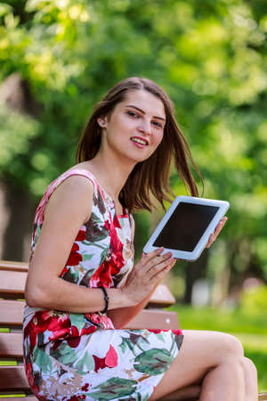 Image of a young happy woman on the phone, discovering gifts in shopping bags on an urban...
