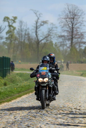 Camphin-en-PÃ©vÃ¨le, France - April 13, 2014: Official bike riding on a cobblestone (Carrefour de l'Arbre) road before the apparition of the peloton during Paris-Roubaix 2014のeditorial素材