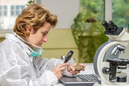 Female geologist researcher analyzing a rock at her workplace.の写真素材
