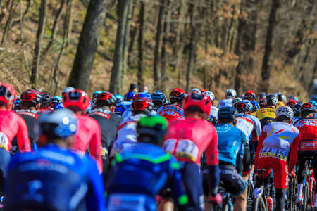 Cote de Senlisse, France - March 7th, 2021: Rear view of the peloton riding on Cote de Senlisse during the stage 1 of Paris - Nice 2021.のeditorial素材