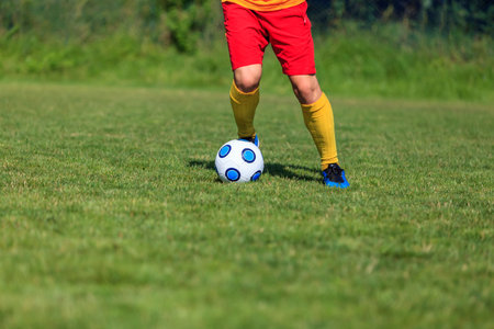 Close-up image of the feet of a footbal player dribblingの写真素材