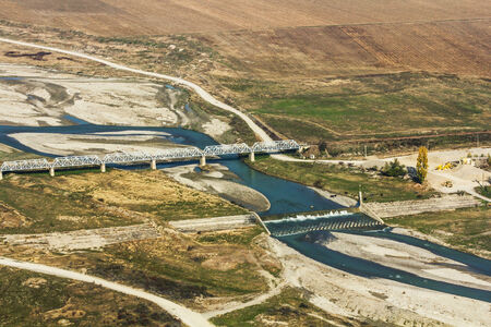 A bridge over a river is placed near a factory - top viewの写真素材