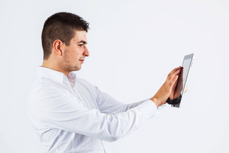 Young handsome businessman holding a tablet in his hands - isolated on whiteのeditorial素材