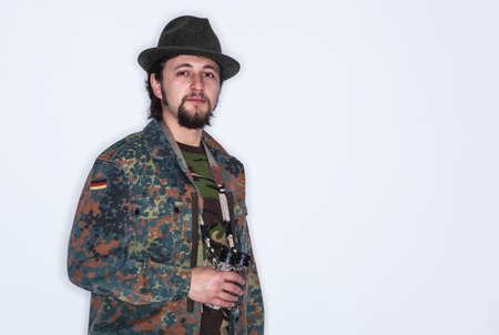 Portrait of a young man wearing camouflage clothes holding a binocular in his hand - isolated on whiteの写真素材