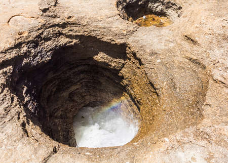 Holes digged in the sand or in rocks with water inside of them.の写真素材