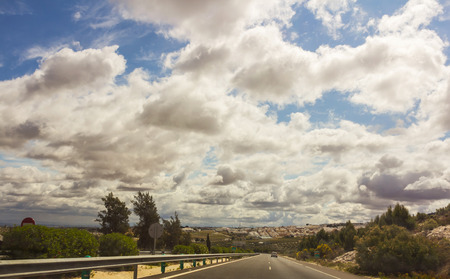 A closeup with clouds almost covering a road.の写真素材