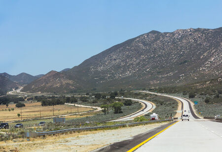 View with cars in the distance on a highway to mountains.の写真素材