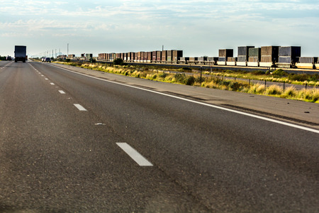 Cargo train passing near Arizona Interstate 10.の写真素材