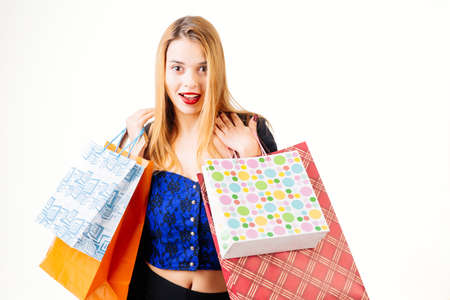 Happy young woman holding shopping bags - isolated on white.