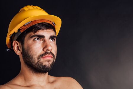 Portrait of an undressed bearded worker looking up - isolated on black.の写真素材