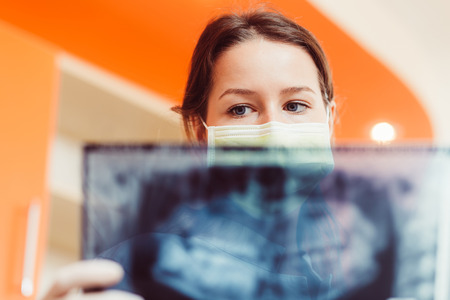 Female doctor or dentist looking at x-rayの写真素材