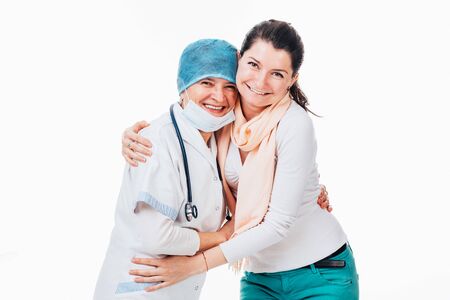 Happy young female patient hugging senior doctor after good news - isolated on whiteの写真素材