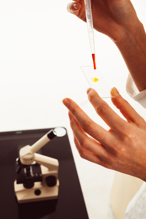 Hands holding a pipette with blood in laboratoryの写真素材