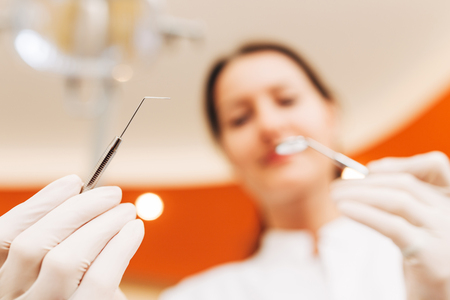Dentist examining patient with dental explorer. Dentist is in blur. Image taken from the patient's perspective.の写真素材