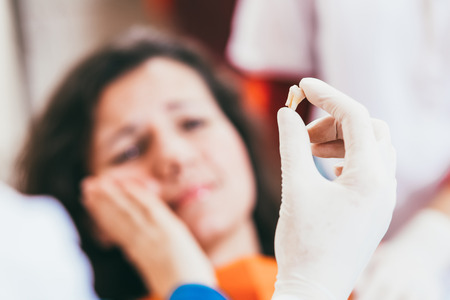 Female in pain after a tooth extracted, close-upの写真素材