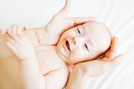 Woman's hands holding her innocence baby boy's head