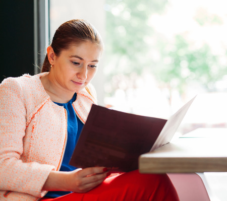 Young woman reading the menu for ordering