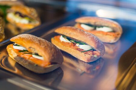 Closeup of baked bruschetta with herbs,eggs and salmon on a tray