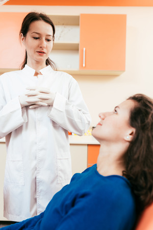Dentist discussing and preparing female patient for the following procedure.の写真素材
