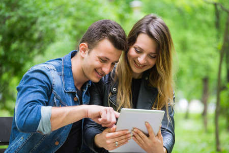 Young couple using digital tablet with joy
