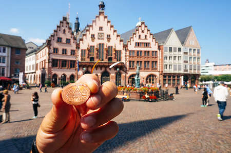 Frankfurt ,Germany - August 22, 2015:  Hand holding a coin souvenir coin with the view of...