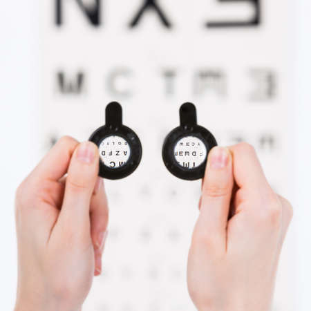 Bucharest, Romania - June 18,2016 : Trial frames used in vision eyesight checkup, eye chart on the backgroundのeditorial素材