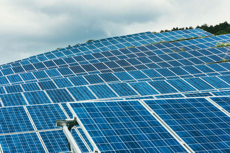 Closeup of modern lines of solar panels on a hill in a cloudy day