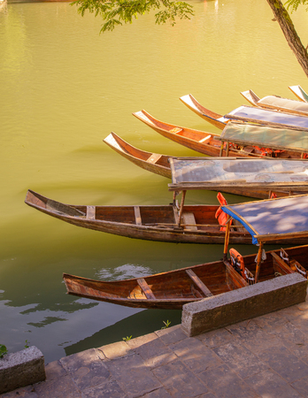 Photo of Ancient City Fenix in China. Historic Asian Scenery with Water Canals, Wooden Houses, Gondola Boatsの写真素材