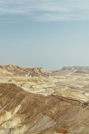 Verical landscape view on dry middle east wilderness in Israel. Valley of sand, rocks and stones in hot tourism place. Scenic outdoor view on wild desert. Summer heat sunlight with nobody on photoの写真素材