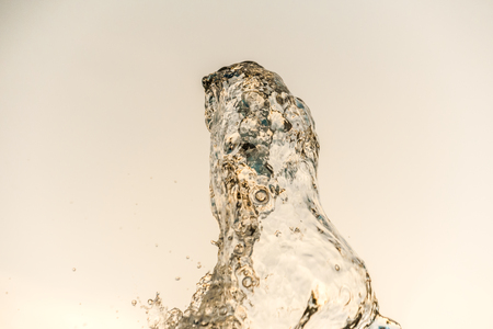 Abstract water wave drop in motion with color background. Natural water splash and bubbles in closeup macro view. Fresh and clean aqua splashing and falling energy.の写真素材