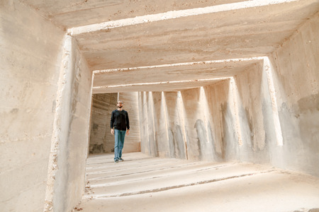Front view of man walking alone in tunnel corridor.の写真素材