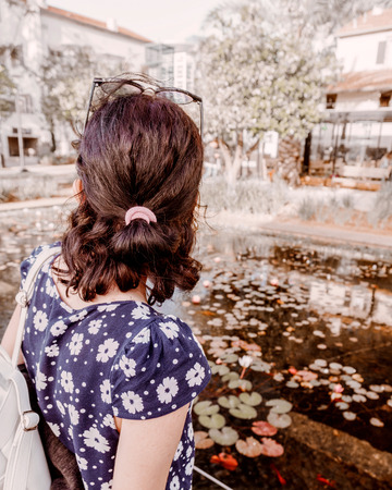Female travel looks on the buildings and water in the center square of the city. Young  attractive...