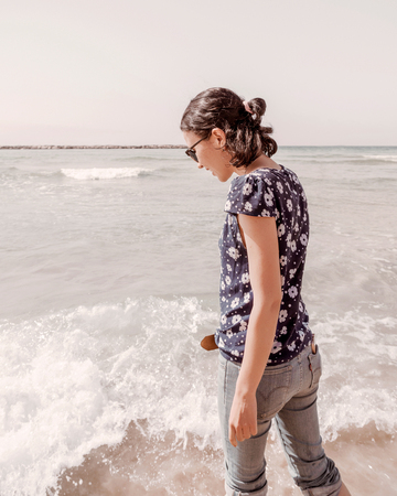 Young beautiful woman in casual clothes and sunglasses near the sea. Sunrise, Summer lifestyle, romantic and relax.の写真素材