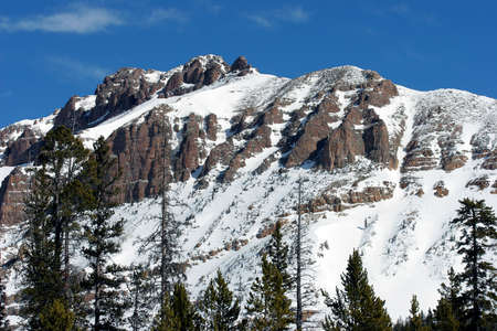 Snowy mountain landscape against a deep blue sky.