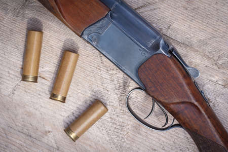 Shotgun forearm with two triggers top view. Rifle charges or cartridges on a wooden surface. Hunting theme, male hobbyの写真素材