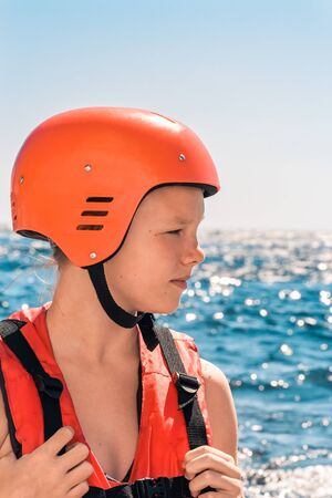 Vertical portrait of girl in orange protective helmet and red li