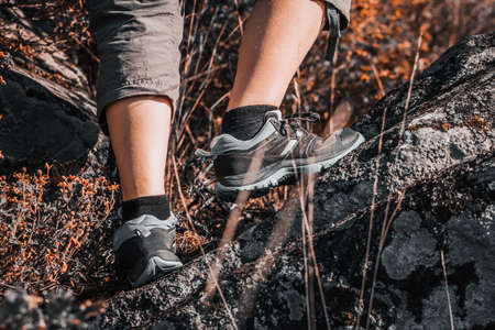Rough hiking boots on rocky stones in mountains. Climbing uphill.の写真素材