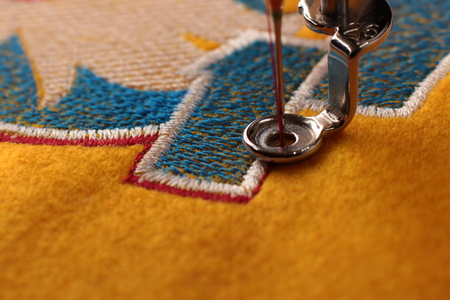 Date 2017 and rooster on yellow felt - embroidery with embroidery machine - Close up of outlining - Foreground and background blanked out blurry の写真素材