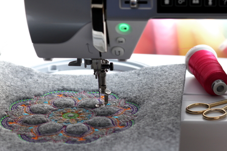 embroidery of colorful mandala on felt with embroidery machine - front view on hoop and machine
の写真素材