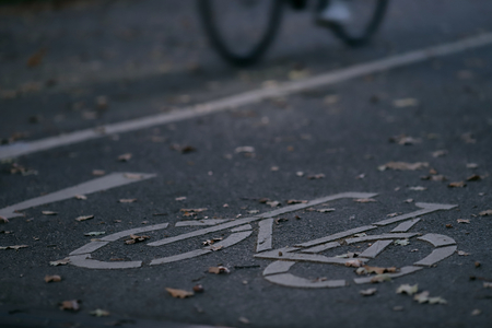 oblique view on cycle path in early morning light with a slow bicycle in background - urban commuting concept - blurred backgroundの写真素材