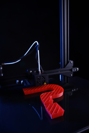 view on 3D-printer making big sculptural question mark from red plastic in blue neon light - dark surrounding - technology opportunity concept - portrait orientationの写真素材