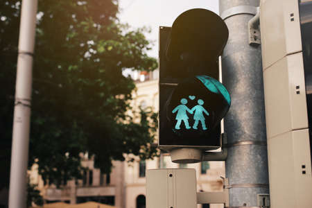 closeup on pedestrian traffic light officially modified for a LGBTQ awareness event showing green graphic of a loving same sex lesbian women couple at a colorful city center - LGBTQ + conceptの写真素材