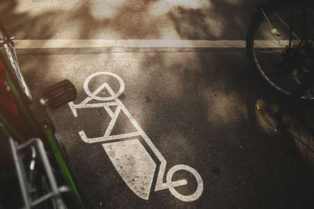 painted cargo bike symbol at an inner city parking lot on a sunny evening. beautiful urban scenery. selective focus on bike icon. modern emission-free mobility conceptの写真素材